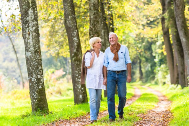 Älteres Paar geht draussen spazieren - unbeschwerter leben und Inkontinenz selbst vorbeugen